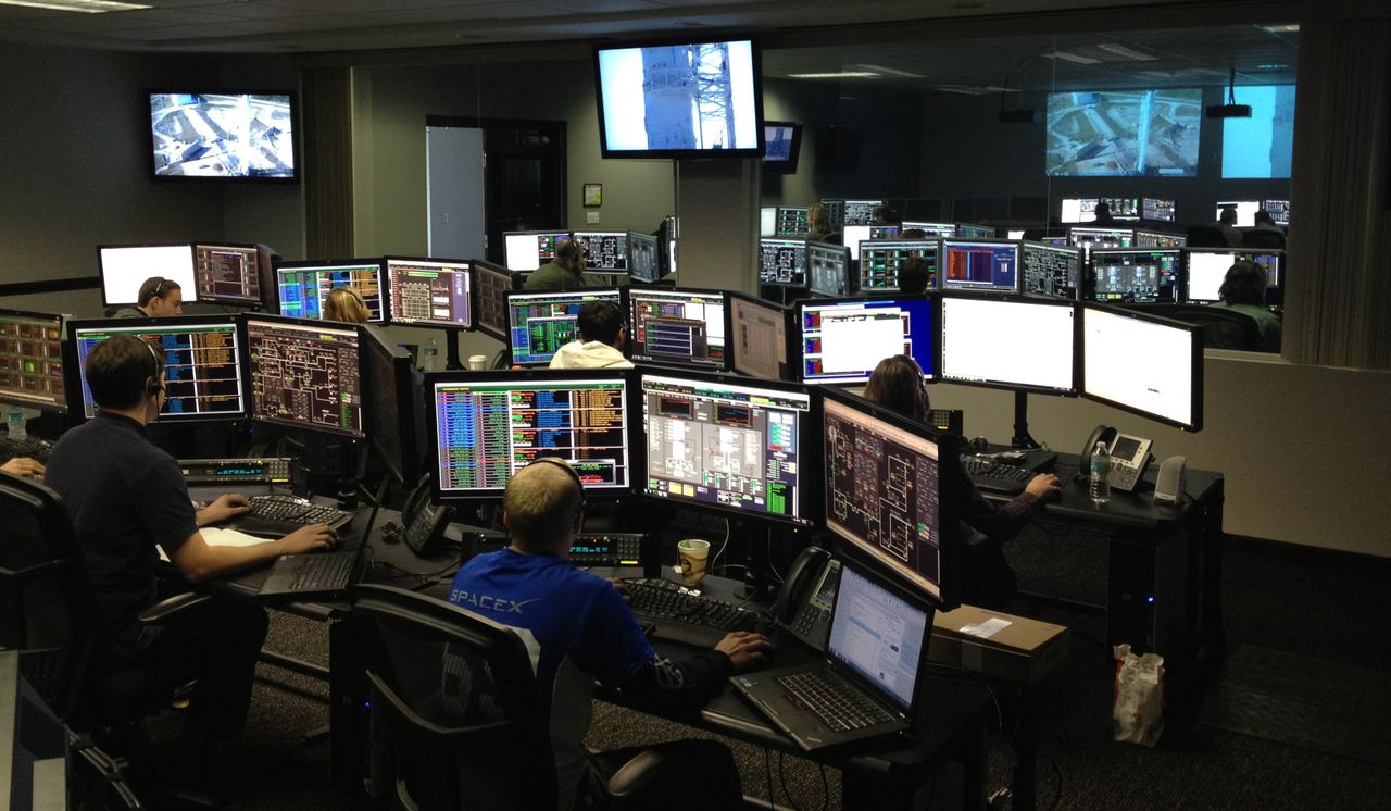 The Art of Drawing Readers In: Your attractive post title goes here A bustling control room with people working on multiple computer monitors.