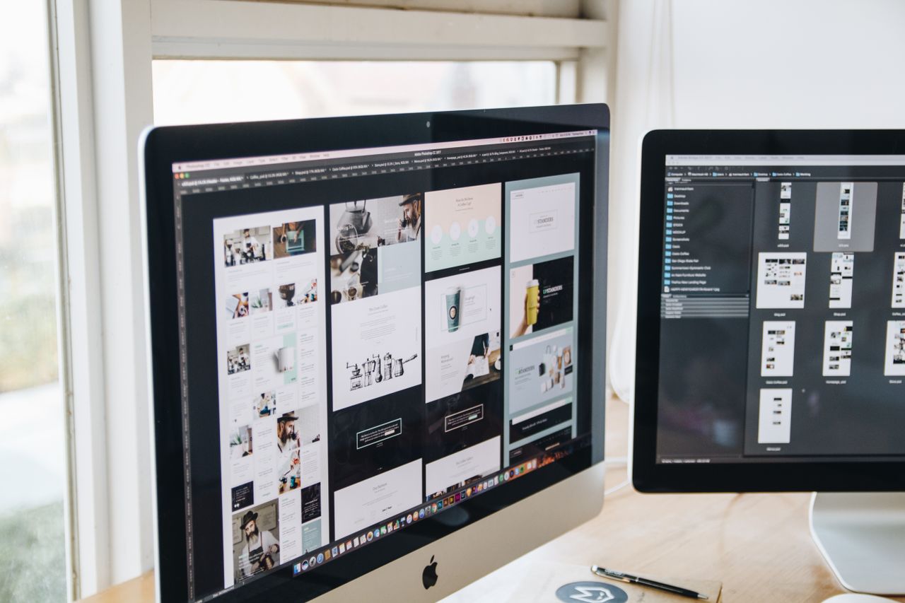 Modern office desk setup with dual monitors displaying design software, ideal for tech and business themes.