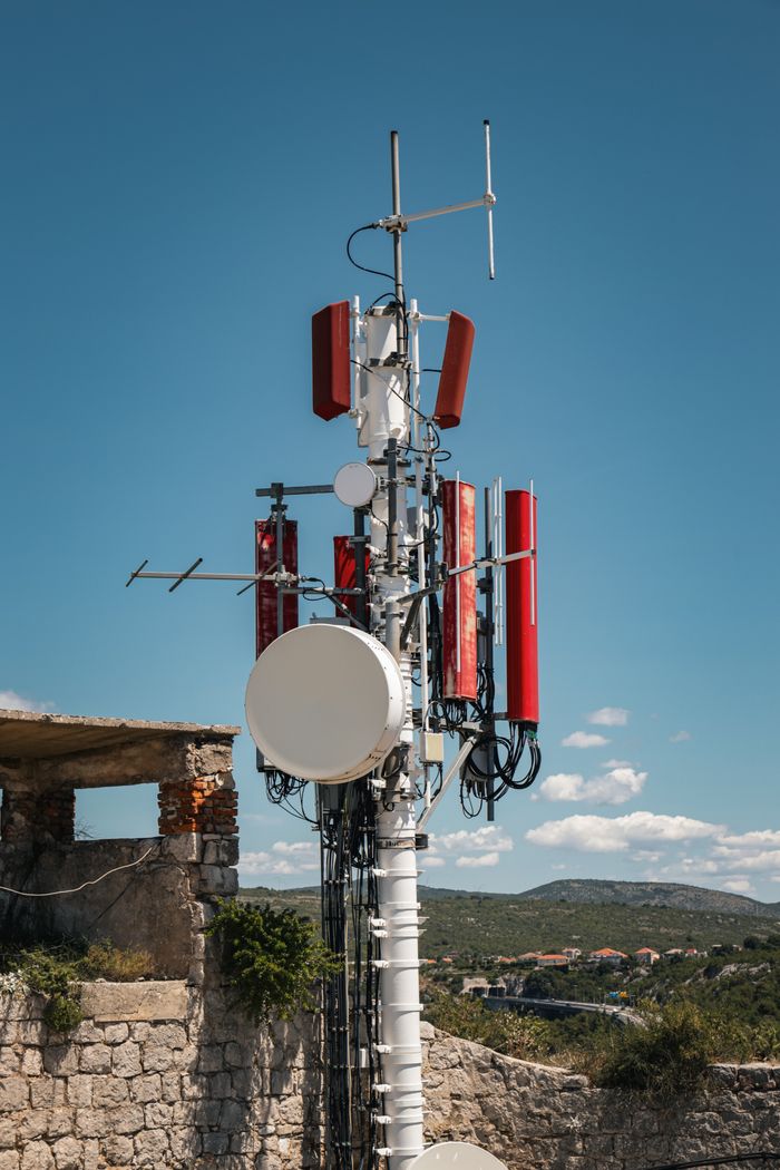 A telecom tower situated in a rustic setting against a bright blue sky in Split, Croatia.