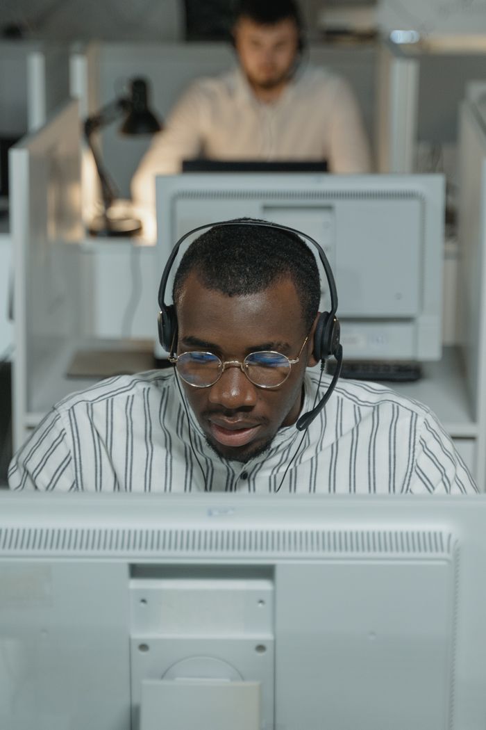 African American call center agent working intently with headset.
